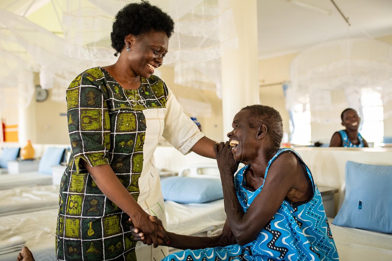 Alice Emasu embracing a woman supported through TERREWODE in Uganda