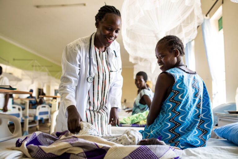 Fistula survivor on hospital bed speaking with doctor