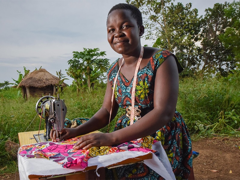 Woman smiling in front of sewing machine