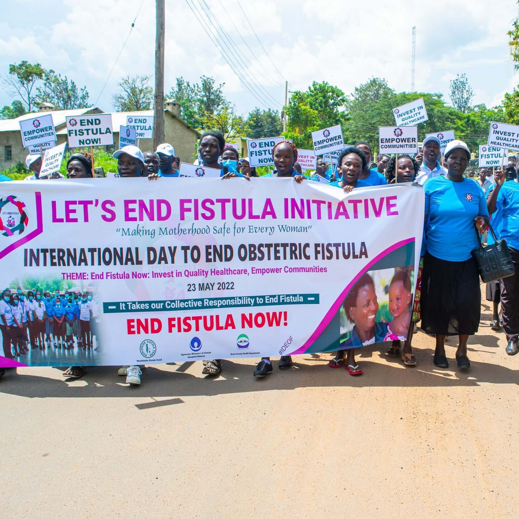 LEFI advocacy walk Community advocates march holding a Let's End Fistula Initiative banner and signs calling for quality healthcare and an end to obstetric fistula.